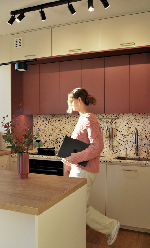 Projektantka wnętrz w zaprojektowanej przez niej beżowo-bordowej kuchni