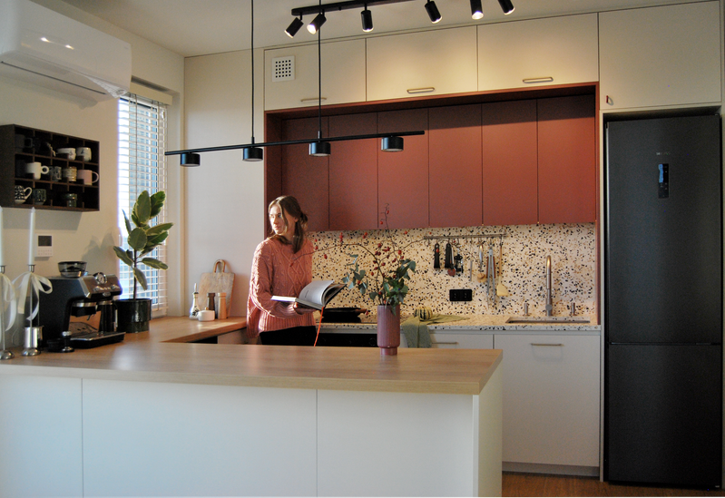 Projektantka wnętrz w zaprojektowanej przez niej beżowo-bordowej kuchni